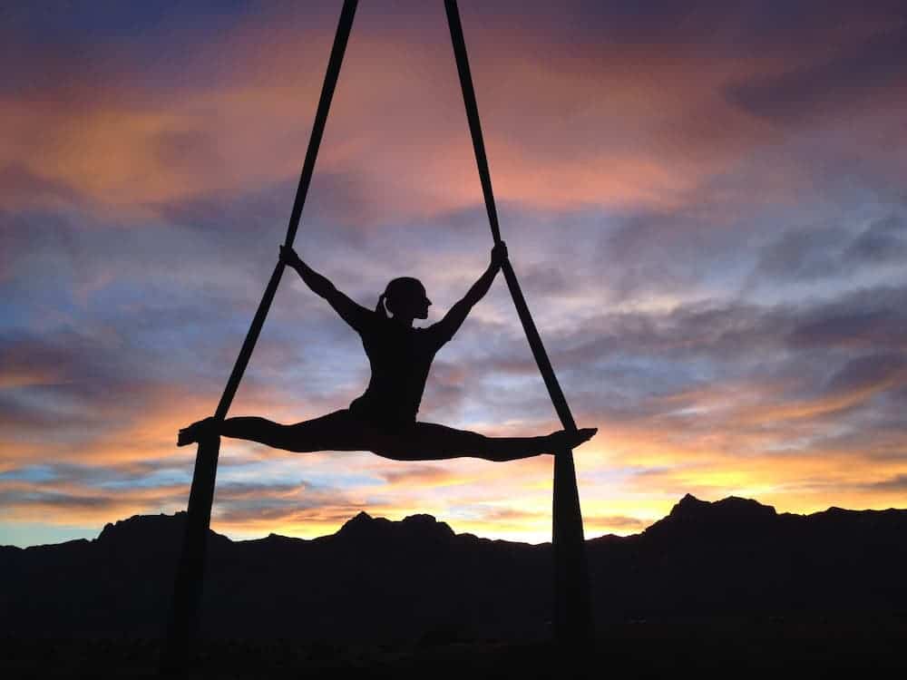 woman practicing aerial yoga at dusk