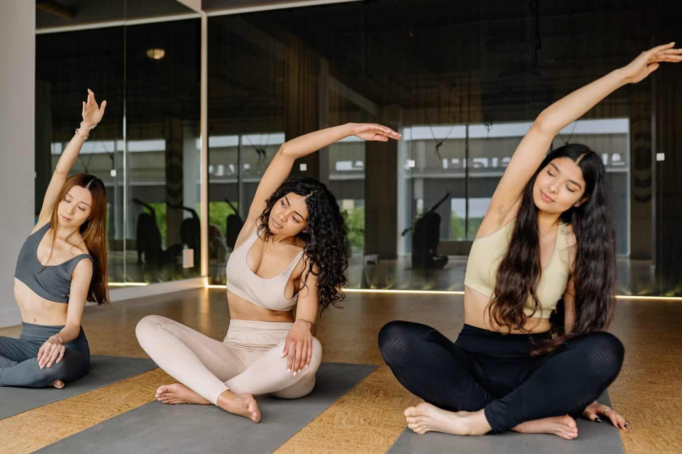 three women stretching in a yoga class